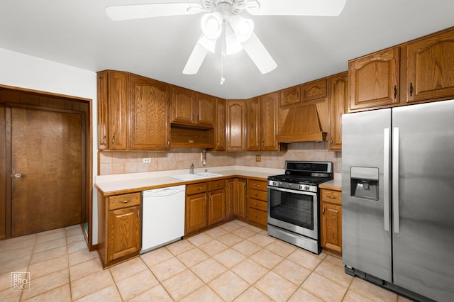 kitchen featuring stainless steel appliances, premium range hood, a sink, light countertops, and tasteful backsplash