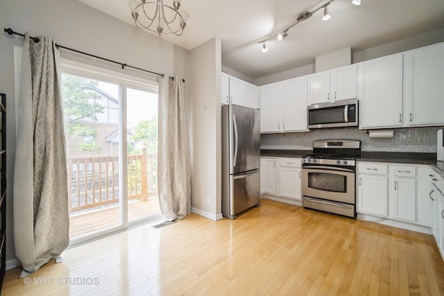 1098 N Claremont Dr Unit 1, Palatine, IL 60074 - kitchen with appliances with stainless steel finishes, dark countertops, backsplash, light wood-style flooring, and white cabinetry