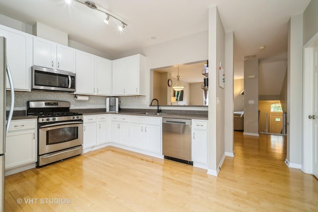 1098 N Claremont Dr Unit 1, Palatine, IL 60074 - kitchen with stainless steel appliances, dark countertops, light wood-style floors, and a sink