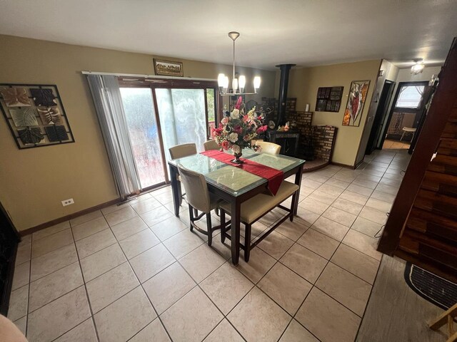 8734 W 99th St, Palos Hills, IL 60465 - dining area with light tile patterned flooring, a chandelier, and baseboards