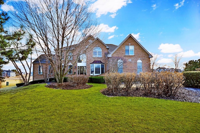 view of front of property featuring brick siding and a front lawn