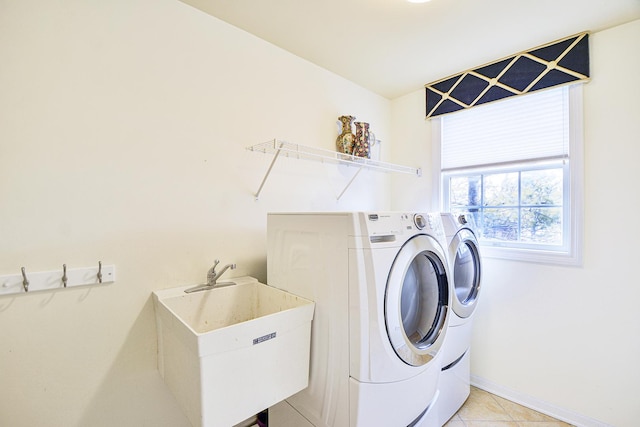 laundry room with washer and clothes dryer, baseboards, and light tile patterned flooring