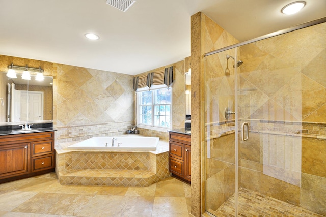 bathroom featuring vanity, a bath, a shower stall, tile walls, and recessed lighting