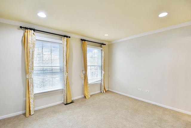 spare room with ornamental molding, recessed lighting, plenty of natural light, baseboards, and light carpet