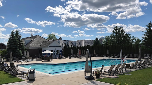 community pool with fence and a patio