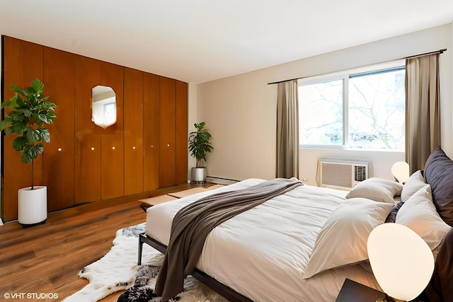 401 W Webster Ave Unit 509, Chicago, IL 60614 - bedroom featuring wood finished floors, baseboard heating, and a wall mounted air conditioner