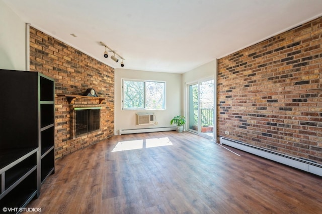 401 W Webster Ave Unit 509, Chicago, IL 60614 - unfurnished living room featuring wood finished floors, a fireplace, a baseboard heating unit, rail lighting, and brick wall