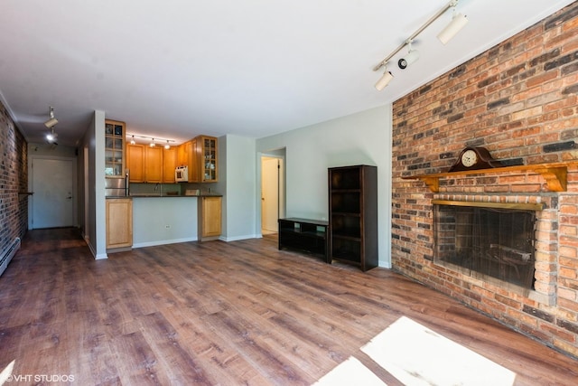 401 W Webster Ave Unit 509, Chicago, IL 60614 - unfurnished living room with a fireplace, rail lighting, brick wall, and wood finished floors