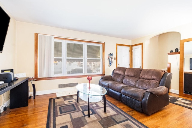 9821 S University Ave, Chicago, IL 60628 - living room with wood finished floors, a desk, baseboards, and arched walkways