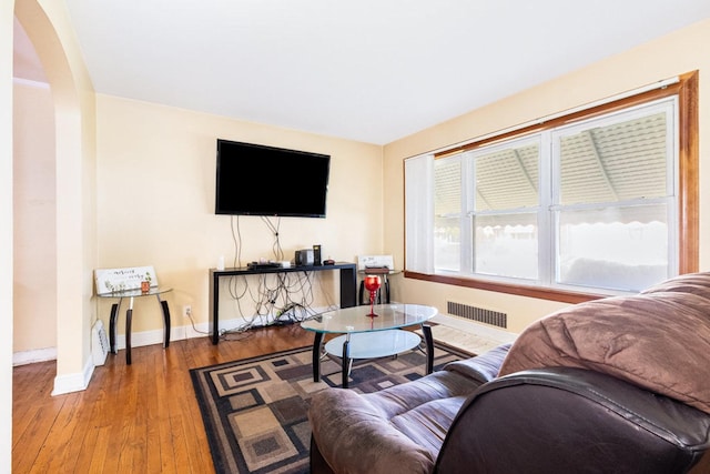 9821 S University Ave, Chicago, IL 60628 - living area featuring baseboards, arched walkways, and wood finished floors