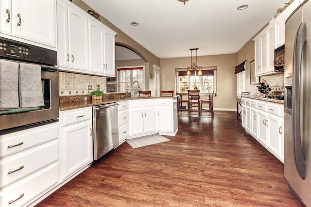 25451 Regent Blvd, Shorewood, IL 60404 - kitchen with appliances with stainless steel finishes, tasteful backsplash, white cabinets, a sink, and arched walkways