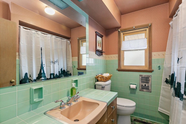 807 S Main St, Belvidere, IL 61008 - bathroom featuring toilet, heating unit, tile walls, wainscoting, and vanity