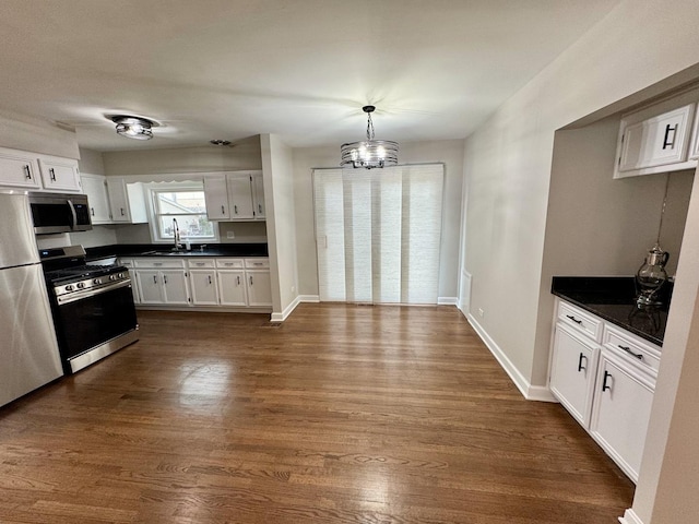 2122 Mandel Ave, Westchester, IL 60154 - kitchen with stainless steel appliances, dark countertops, a sink, and white cabinets