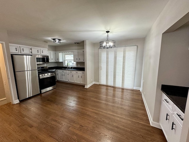 2122 Mandel Ave, Westchester, IL 60154 - kitchen featuring stainless steel appliances, a sink, dark countertops, white cabinetry, and a chandelier