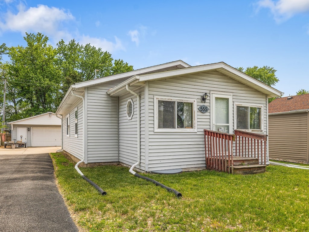 555 Marquette Rd, Machesney Park, IL 61115 - view of front of home with a garage, an outdoor structure, and a front lawn