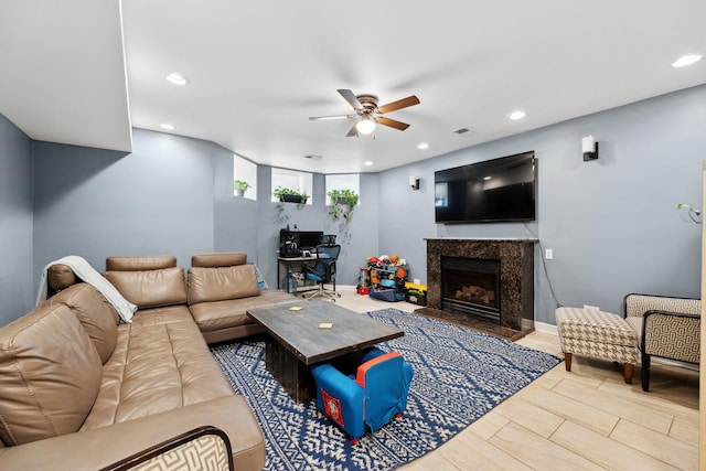 living room featuring a ceiling fan, a high end fireplace, and recessed lighting