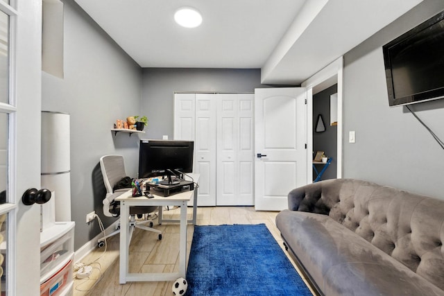 office area featuring light wood-type flooring and baseboards
