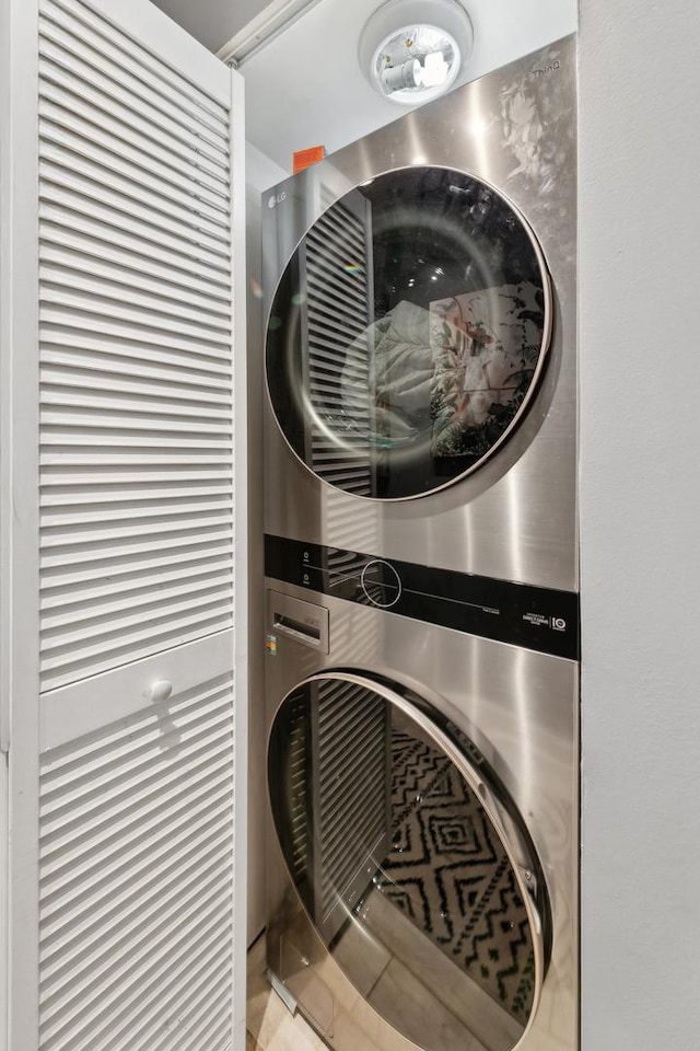 clothes washing area featuring stacked washing machine and dryer