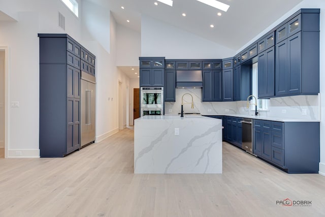 kitchen featuring stainless steel appliances, a skylight, ventilation hood, a sink, and glass insert cabinets