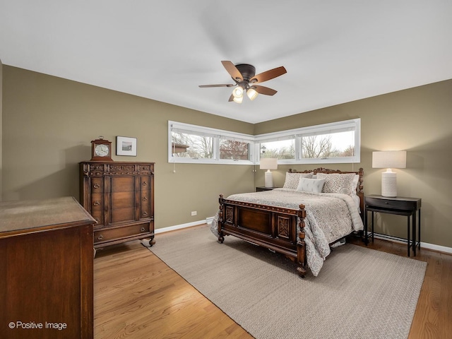 bedroom with baseboards, wood finished floors, and ceiling fan