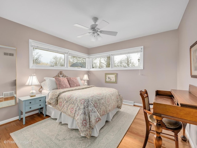 bedroom with multiple windows, baseboards, and light wood finished floors