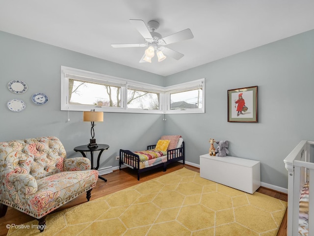 bedroom with light wood-style floors, baseboards, and a ceiling fan