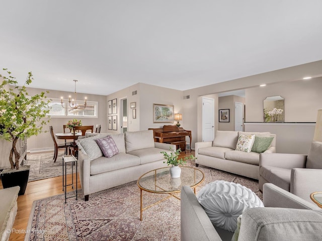 living area with a chandelier, light wood-type flooring, and baseboards