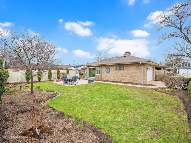 rear view of house with a garage, brick siding, a chimney, a patio area, and a shingled roof