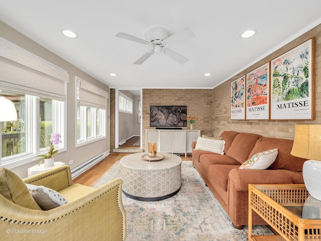 living room with a baseboard radiator, wood finished floors, recessed lighting, a ceiling fan, and brick wall