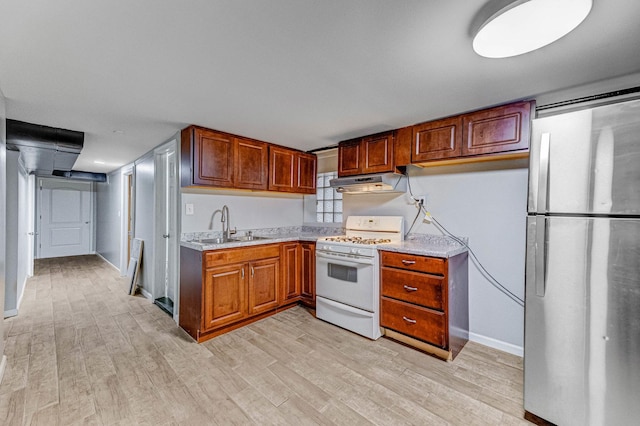 1230 S 57th Ct, Cicero, IL 60804 - kitchen with white range with gas cooktop, freestanding refrigerator, under cabinet range hood, a sink, and light wood finished floors