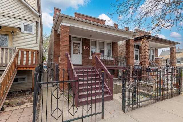 1230 S 57th Ct, Cicero, IL 60804 - shotgun-style home featuring stairs, a fenced front yard, brick siding, and a porch