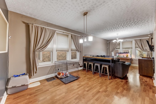 1230 S 57th Ct, Cicero, IL 60804 - dining room with a chandelier, wood finished floors, baseboards, and a textured ceiling