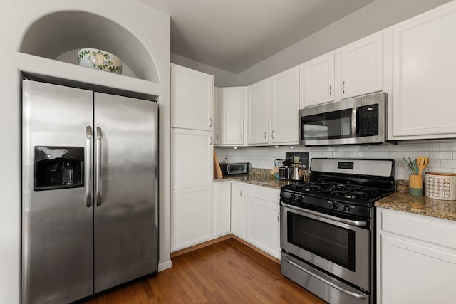 16030 Tahoe Ln, Crest Hill, IL 60403 - kitchen with appliances with stainless steel finishes, white cabinets, dark wood-style flooring, dark stone counters, and decorative backsplash