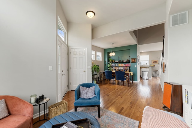 16030 Tahoe Ln, Crest Hill, IL 60403 - living room featuring light wood-style floors, a chandelier, and baseboards