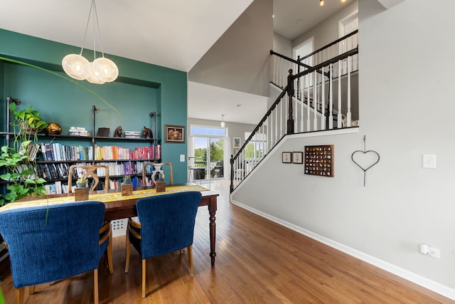 16030 Tahoe Ln, Crest Hill, IL 60403 - dining area with stairs, baseboards, wood finished floors, a chandelier, and a high ceiling