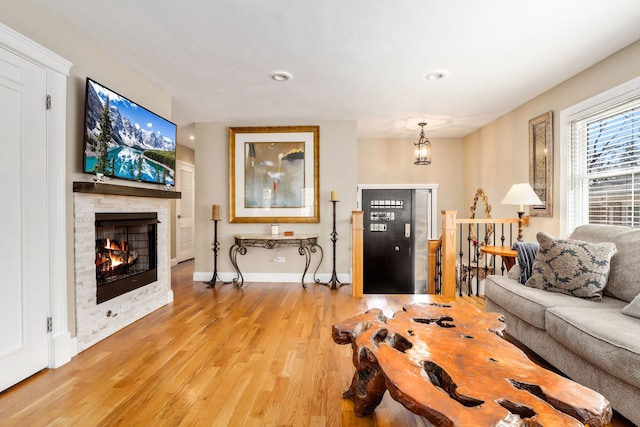 2936 Warbler Pl, Highland Park, IL 60035 - living room featuring light wood-style floors, a stone fireplace, baseboards, recessed lighting, and a chandelier