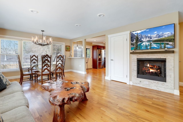2936 Warbler Pl, Highland Park, IL 60035 - living area with a chandelier, light wood finished floors, baseboards, and a stone fireplace