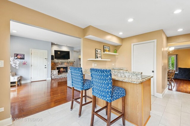 670 Ballantrae Dr Unit 900C, Northbrook, IL 60062 - kitchen featuring light stone counters, a kitchen bar, baseboards, open shelves, and recessed lighting
