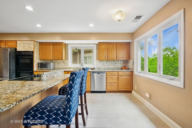 670 Ballantrae Dr Unit 900C, Northbrook, IL 60062 - kitchen featuring appliances with stainless steel finishes, decorative backsplash, baseboards, light stone countertops, and recessed lighting