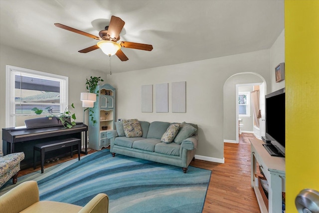 505 S Maple St, Urbana, IL 61801 - living room featuring arched walkways, a ceiling fan, wood finished floors, and baseboards