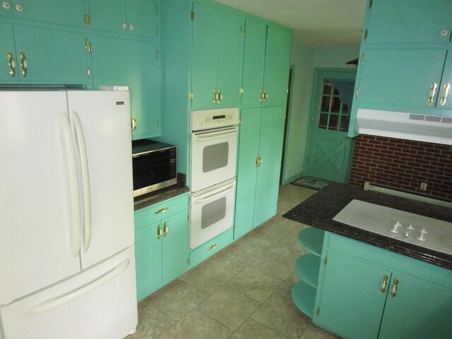 kitchen featuring white appliances, ventilation hood, and dark countertops