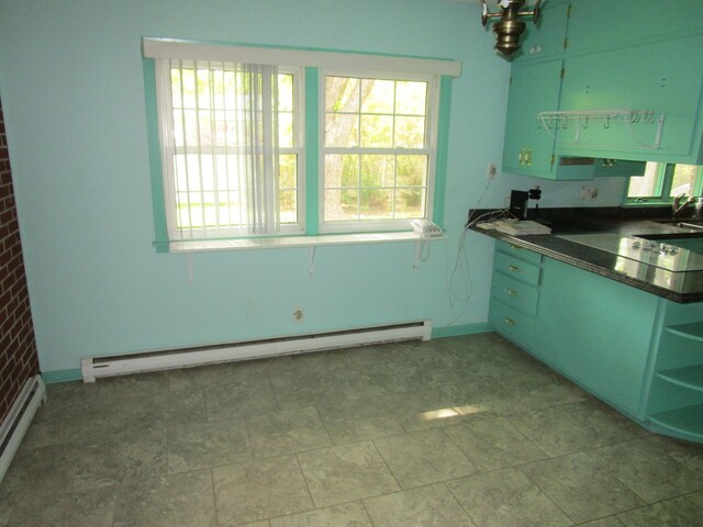 kitchen featuring baseboard heating, open shelves, dark countertops, a baseboard heating unit, and baseboards