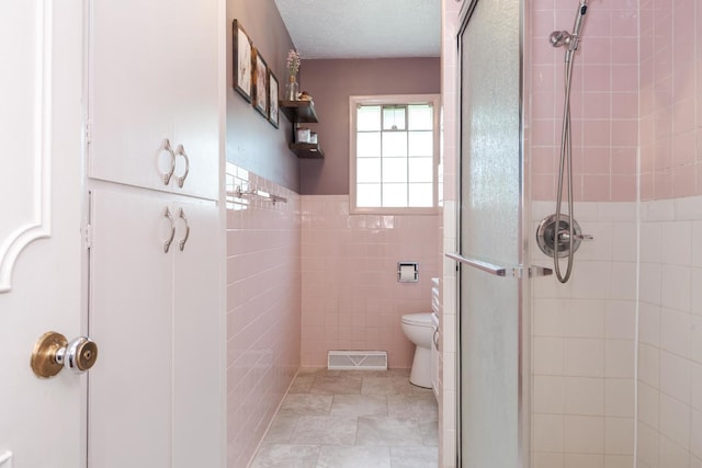 504 Delmar Ln, Bloomington, IL 61701 - full bath featuring a stall shower, tile walls, wainscoting, and a textured ceiling