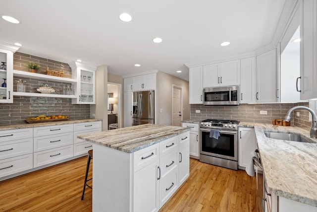 424 Dilorenzo Dr, Naperville, IL 60565 - kitchen with appliances with stainless steel finishes, a sink, backsplash, a breakfast bar area, and a kitchen island