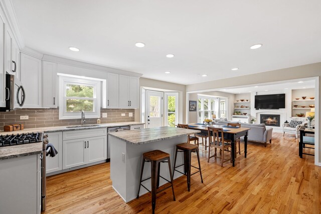 424 Dilorenzo Dr, Naperville, IL 60565 - kitchen featuring a sink, appliances with stainless steel finishes, light wood-type flooring, a kitchen breakfast bar, and tasteful backsplash