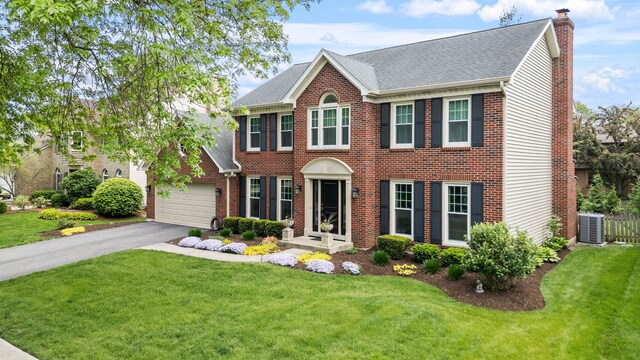 424 Dilorenzo Dr, Naperville, IL 60565 - colonial-style house featuring a chimney, brick siding, asphalt driveway, a front lawn, and a garage
