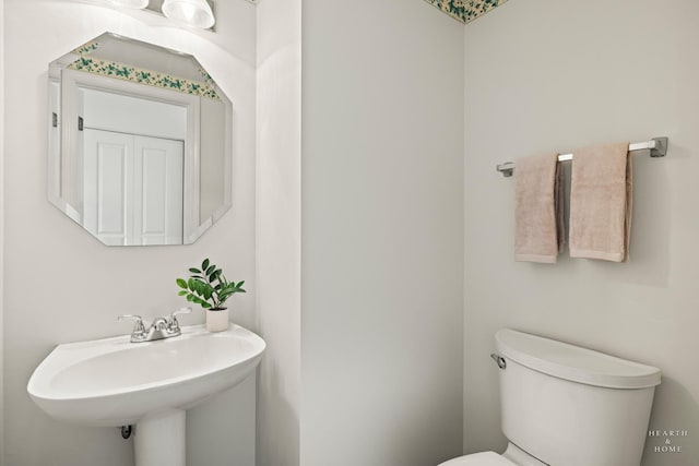 half bath with toilet and a sink