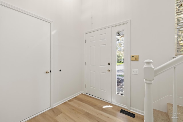 entryway with light wood-style flooring and baseboards