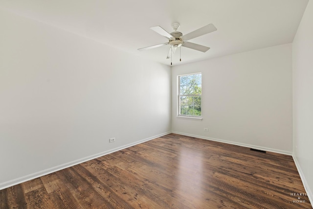 unfurnished room with baseboards, dark wood-style floors, and a ceiling fan