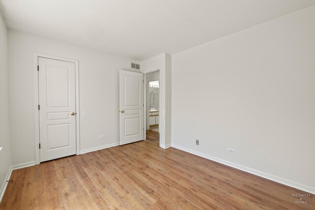 unfurnished bedroom with baseboards and light wood-style flooring